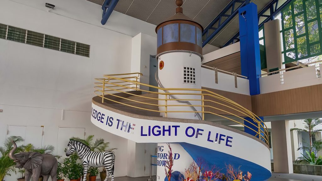 School spiral staircase, designed to look like a lighthouse. The words ' Knowledge is the Light of Life' sprawl across the exterior of the stairs