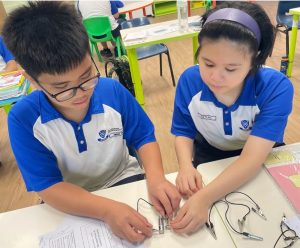 Students connecting a battery circuit together.